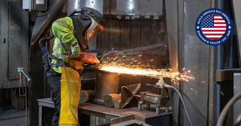 American cast iron worker in a U.S. foundry grinds a municipal box to meet Bingham & Taylor quality standards