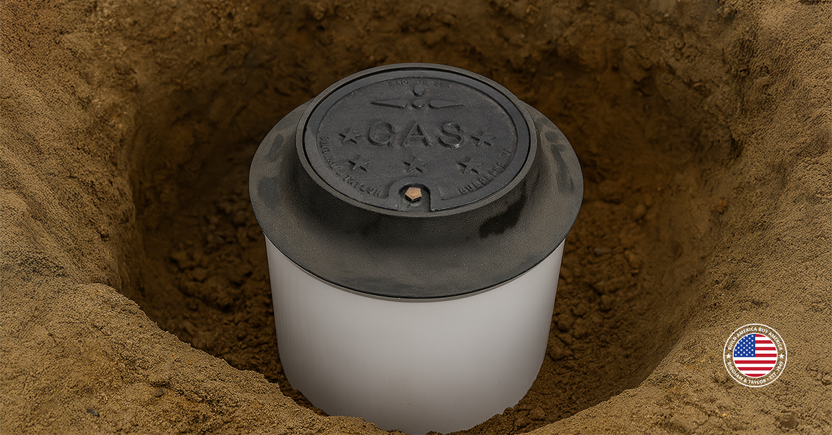 Partially installed meter pit with GAS cast iron lid, cast iron frame shown in a cross-section of soil.